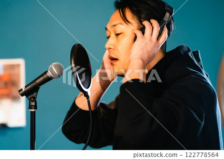 一名年輕人在音響設備前錄音 一名年輕人在音響設備前錄音 122778564