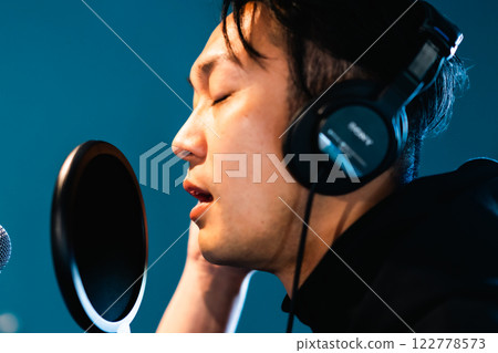 一名年輕人在音響設備前錄音 一名年輕人在音響設備前錄音 122778573