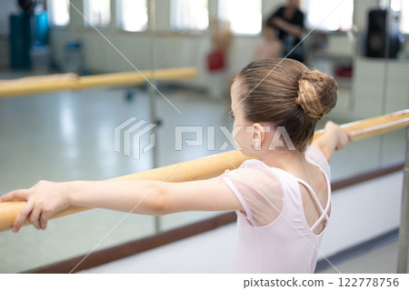 Cute little girl toddler ballerina in pale pink tutu and ballet shoes practicing dance moves. 122778756