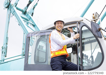 Worker working at a construction site A man operating a crane 122779340