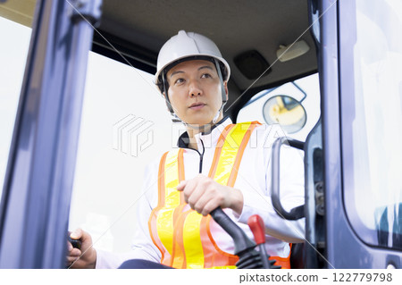 Worker working at a construction site A man operating a crane 122779798