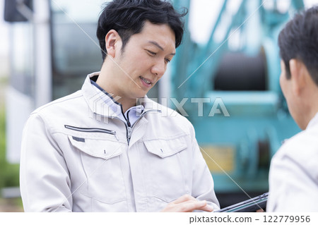 建築工地的工人：一名男子在平板電腦上查看工作詳情 122779956