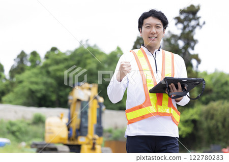 Worker working at a construction site Man holding a tablet 122780283
