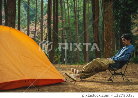 solo traveler in nature concept with asian man camping and see pink cherry blossom tree and pine tree with sunrise in springtime season solo traveler in nature concept with asian man camping and see pink cherry blossom tree and pine tree with sunrise in springtime season 122780353