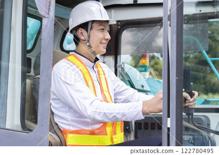 Worker working at a construction site A man operating a crane 122780495