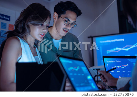 team of financial discussion budget planning, analyzing digital financial data and strategy in a modern office at night team of financial discussion budget planning, analyzing digital financial data and strategy in a modern office at night 122780876