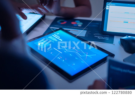 close up team of financial discussion fintech technology planning, analyzing digital financial data and strategy in a modern office at night close up team of financial discussion fintech technology planning, analyzing digital financial data and strategy in a modern office at night 122780880