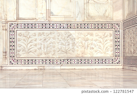 Ancient carved floral decor on marble wall in Taj Mahal, India. Details of decor of Taj Mahal mausoleum. Bas-relief pattern with flowers and frame ornament inlaid with jasper and precious stones Ancient carved floral decor on marble wall in Taj Mahal, India. Details of decor of Taj Mahal mausoleum. Bas-relief pattern with flowers and frame ornament inlaid with jasper and precious stones 122781547