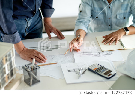 Architects and Engineers A man and woman are standing and sitting 122782178