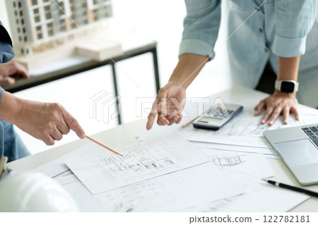 Architect or engineer in brainstorm meeting is pointing out design details 122782181
