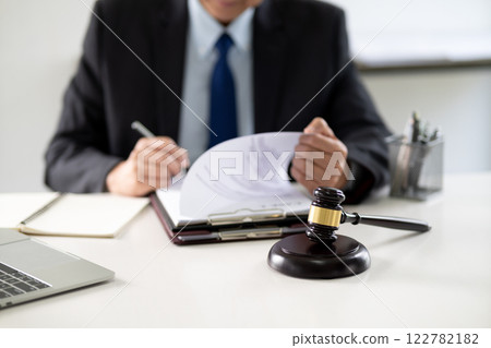 lawyer write drafts a legal document at a desk with stationery lawyer write drafts a legal document at a desk with stationery 122782182