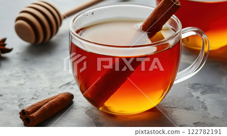 clear glass cup of tea with cinnamon stick and honey on table 122782191