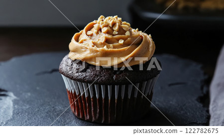 Delicious chocolate cupcake topped with creamy peanut butter frosting and nuts 122782675
