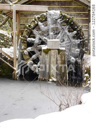 Snow-covered and frozen watermill Snow-covered and frozen watermill 122784168