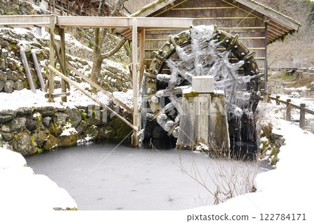 Snow-covered and frozen watermill 122784171