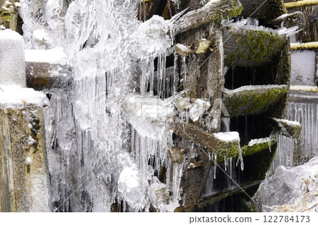 Snow-covered and frozen watermill Snow-covered and frozen watermill 122784173