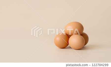 Fresh brown eggs isolated on a light beige background with space for text, lying horizontally. 122784299