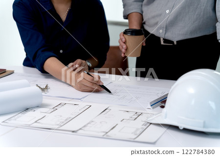 Architects or engineers are pointing at plans to discuss project design 122784380