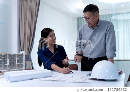 Architects or engineers are pointing at plans to discuss project design 122784382