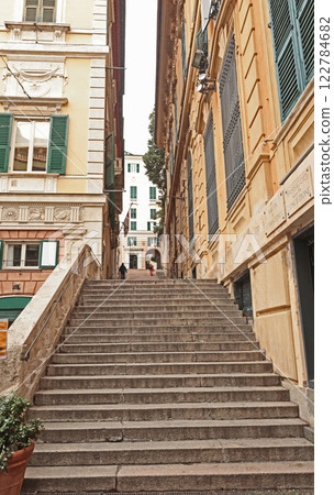 Traditional buildings and steps, pedestrianized narrow streets of old town. Genoa and medieval architecture of Italy. Windows and doors.  122784682