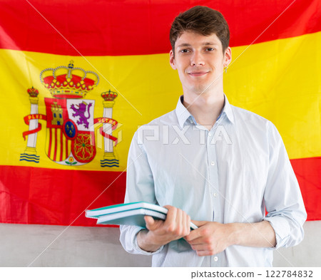 Positive student on background of flag of Spain - concept of studying abroad and immigration Positive student on background of flag of Spain - concept of studying abroad and immigration 122784832