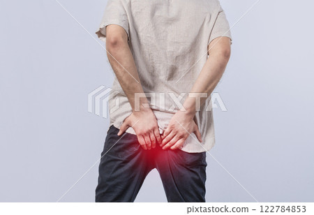 Man with diarrhea problem, man with digestive problem touching his buttock, man with hemorrhoid problem on isolated background Man with diarrhea problem, man with digestive problem touching his buttock, man with hemorrhoid problem on isolated background 122784853
