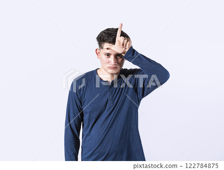 Unhappy man holding hand near forehead showing loser gesture with fingers, man gesturing someone loser Unhappy man holding hand near forehead showing loser gesture with fingers, man gesturing someone loser 122784875