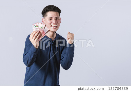 Excited man with money in his hand, astonished man with banknotes in his hand, concept of man earning money Excited man with money in his hand, astonished man with banknotes in his hand, concept of man earning money 122784889