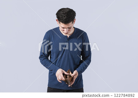 Man seeing his empty wallet, young man with wallet without money, unhappy and stressed man looking in an empty wallet Man seeing his empty wallet, young man with wallet without money, unhappy and stressed man looking in an empty wallet 122784892