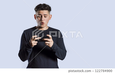 Man holding cell phone horizontally, Guy gasping and playing games on his smartphone 122784900