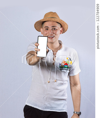 Man with beach hat showing the screen of his cell phone, beach man showing the screen of the cell phone Man with beach hat showing the screen of his cell phone, beach man showing the screen of the cell phone 122784909