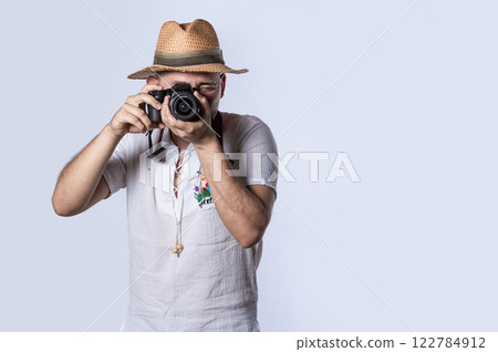 tourist in a hat with a camera, Happy tourist in a hat with a camera around his neck 122784912