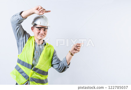 Portrait of smiling engineer pointing aside isolated. Handsome engineer pointing an advertisement isolated Portrait of smiling engineer pointing aside isolated. Handsome engineer pointing an advertisement isolated 122785037