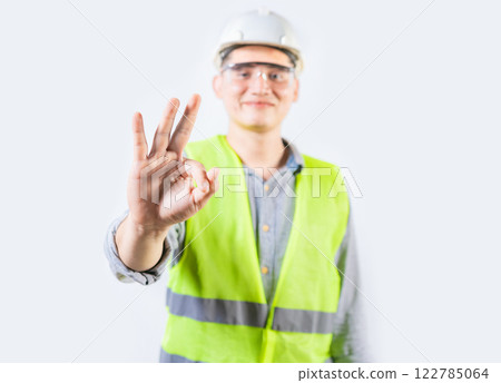 Young engineer counting number three isolated. Male engineer showing number three with fingers isolated Young engineer counting number three isolated. Male engineer showing number three with fingers isolated 122785064