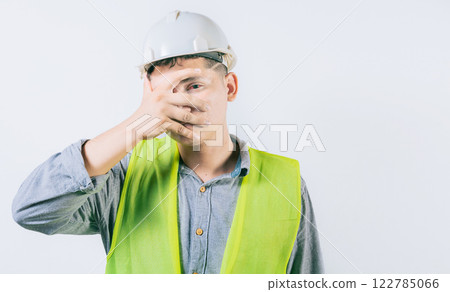 Man engineer with irritated eyes isolated. Young engineer with conjunctivitis on isolated background Man engineer with irritated eyes isolated. Young engineer with conjunctivitis on isolated background 122785066