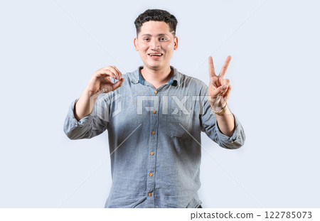 Interpreter man gesturing LOVE AND PEACE in sign language isolated. Smiling person making gesture LOVE AND PEACE in sign language 122785073