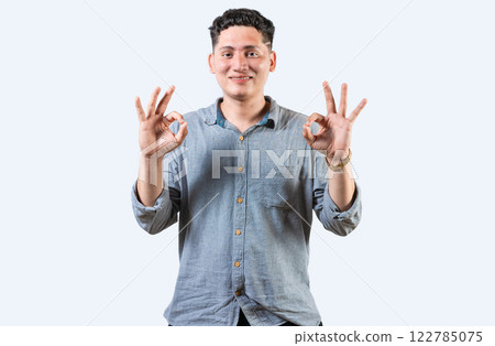 Interpreter person gesturing OK in sign language. Smiling young man gesturing APPROVED in sign language 122785075