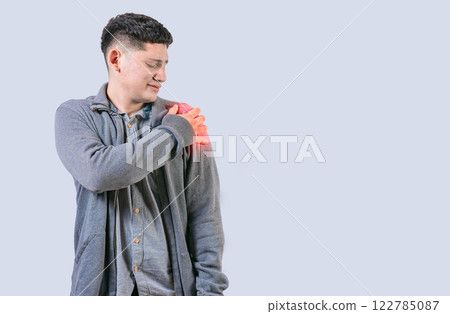 Person in pain holding his shoulder isolated. Youg man suffering with arms pain isolated 122785087