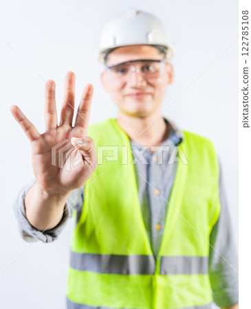 Young engineer counting number four isolated. Male engineer showing number four with fingers isolated 122785108