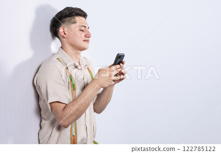 Handsome guy happy with his cell phone on isolated backgrounds, young latin man happy with his cell phone isolated, man on white background texting with his cell phone 122785122