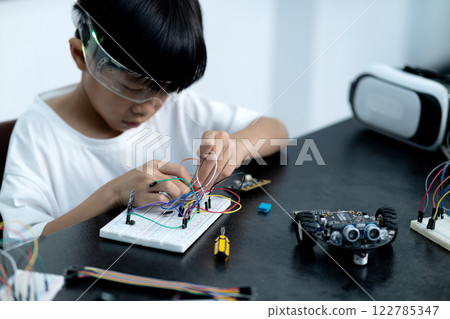 young boy having fun connecting electronic circuit board 122785347
