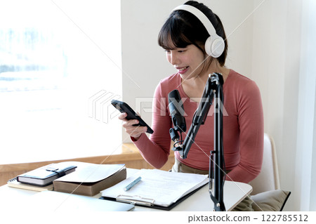 Young asian woman are using smart phones along with other forms of communication 122785512