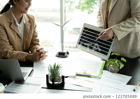 Presentation of details of invention innovations at the meeting businesswoman I'm pointing to the solar panel model to explain the benefits of the product and the ways of renewable energy. 122785889