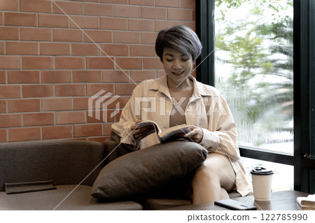 adult woman is sitting comfortably in a cozy corner 122785990