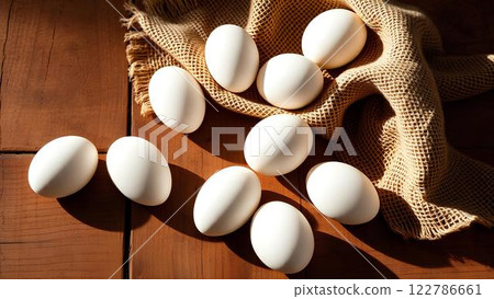 Fresh white chicken eggs on rye fabric, burlap on wooden brown surface in rustic interior. Rustic style, warmth and texture. Fresh white chicken eggs on rye fabric, burlap on wooden brown surface in rustic interior. Rustic style, warmth and texture. 122786661