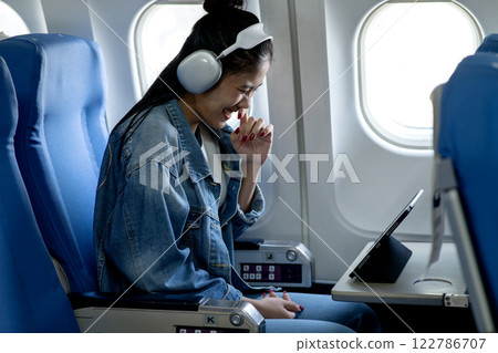 Young woman wearing headphones looking at tablet or computer Young woman wearing headphones looking at tablet or computer 122786707