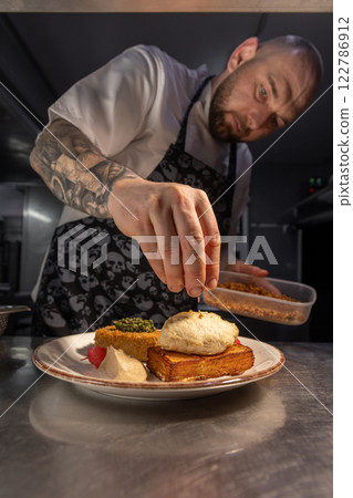 Chef garnishing gourmet dish 122786912