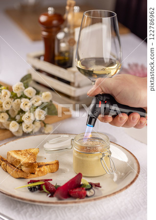 Chef caramelizing creme brulee with a torch 122786962