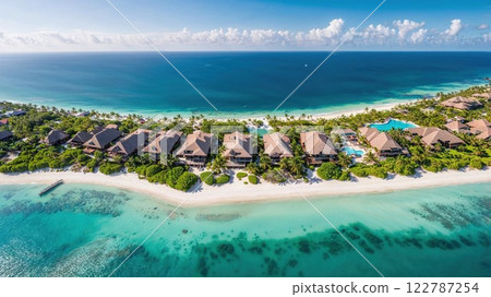 Aerial view of luxurious beachfront villas surrounded by turquoise waters, lush greenery, and pristine white sand, capturing the ultimate tropical paradise 122787254