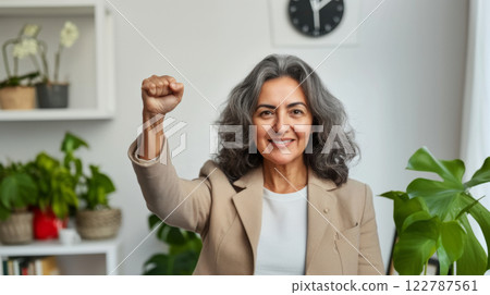 Middle aged hispanic woman with raised fist of empowerment, strength and women solidarity, International Womens Day concept 122787561